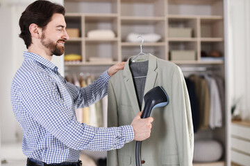 Man steaming jacket with stand steamer indoors