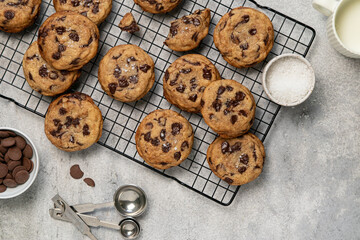 Homemade American brown butter chewy, fluffy and soft chocolate chip cookies on a cooling rack with salt and milk. Biscuits for children. Top view, copy space.