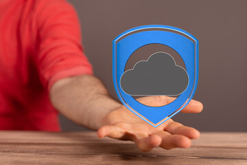 Image of a hand holding a digital shield protecting a cloud, symbolizing secure cloud data.