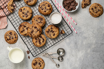 Homemade American brown butter chewy, fluffy and soft chocolate chip cookies on a cooling rack with salt and milk. Biscuits for children. Top view, copy space.