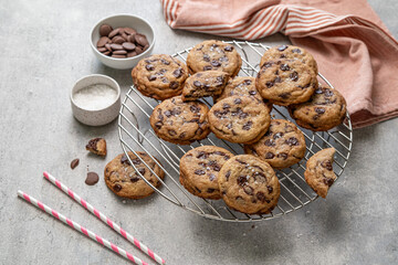 Homemade American brown butter chewy, fluffy and soft chocolate chip cookies on a cooling rack with salt. Biscuits for children. Selective focus.