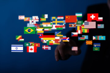 Plakat Image of a hand interacting with a digital display of world flags, symbolizing global connection and communication.