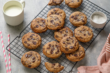 Homemade American brown butter chewy, fluffy and soft chocolate chip cookies on a cooling rack with salt and milk. Biscuits for children. Selective focus.
