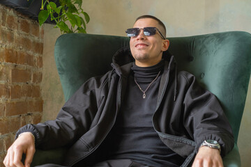 Young man in black smiling indoors on a cool day in an cafe