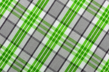 The texture of linen fabric in a large cage of blue, green, brown and white. Scottish tailoring material. Checkered fabric