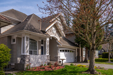 Two story stucco luxury house with nice spring blossom landscape in Vancouver, Canada, North...