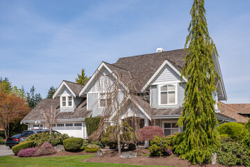 Two story stucco luxury house with nice spring blossom landscape in Vancouver, Canada, North...