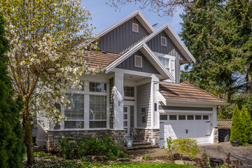 Two story stucco luxury house with nice spring blossom landscape in Vancouver, Canada, North America. Day time on May 2025.