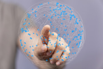 Abstract image of a hand interacting with a digital global network. Represents connection,...