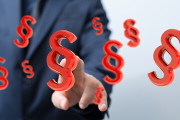 Businessman touching 3D paragraph symbols. Law, justice, legal concept.