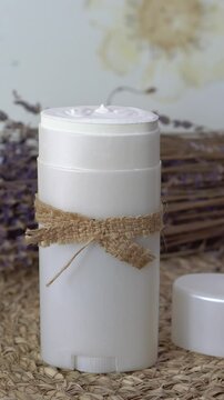 Homemade natural SPF stick with zinc oxide on white and beige background. Organic sun protection balm with dry lavender flower. Zero waste skincare. DIY sunscreen for summer skincare.