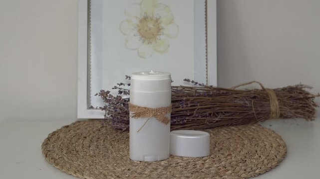 Homemade natural SPF stick with zinc oxide on white and beige background. Organic sun protection balm with dry lavender flower. Zero waste skincare. DIY sunscreen for summer skincare.