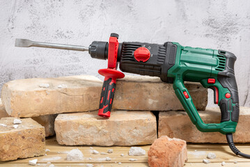 Electric drill and bricks on wooden background