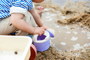  강가 모래사장에서 노는 귀여운 유아
