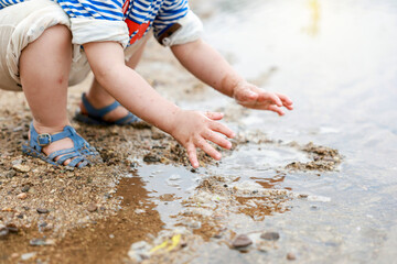  강가 모래사장에서 노는 귀여운 유아