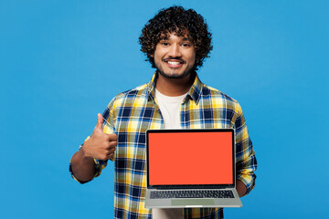 Young IT Indian man he wear yellow checkered shirt casual clothes hold use work on laptop pc...