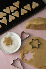 Shapes from baking dough, making Christmas cookies.
Vertical photo.