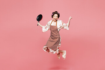 Full body young housewife housekeeper chef cook baker woman wear brown apron jump high with frying...