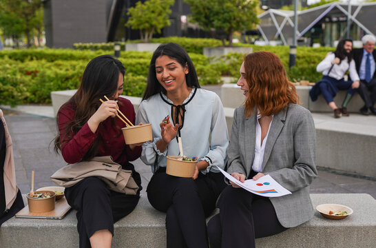 Multiracial business women having fun together during lunch break outside of office - Entrepreneur, diverse colleagues and food concept