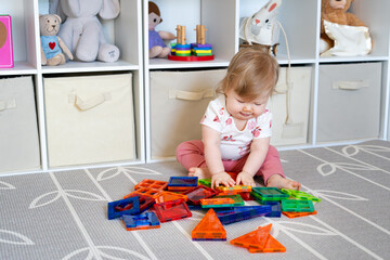 Adorable Baby Girl Playing with Colorful Magnetic Tiles on Nursery Floor, Learning Shapes, Early Childhood Development, Educational Toy Concept, Montessori Inspired Playroom. 