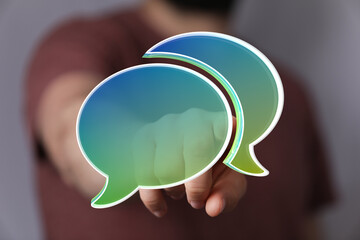 Hand points at glowing speech bubbles,communication, dialogue, conversation concept.
