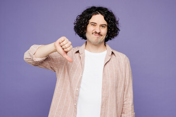 Young sad disappointed brunet man he wearing pink shirt t-shirt casual clothes showing thumb down...