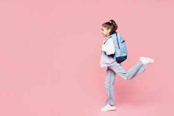 Full body side view young school girl 8-9 years old wear blue casual clothes backpack hold books...