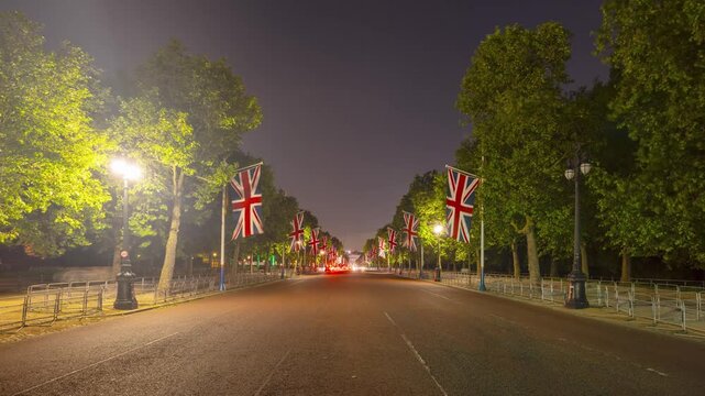 Night time lapse of traffic on the flag lined road leading to Buckingham Palace in London at night.