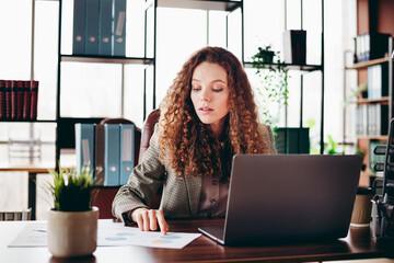 Successful Young Professional Businesswoman Working in Office on Laptop and Reviewing Documents