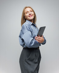 Confident Professional Woman in Stylish Attire Holding Tablet While Smiling at Camera in an Elegant...