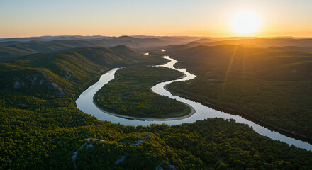 A wide aerial view of a winding river cutting through green forest.
