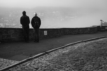 Men observing a misty town from above