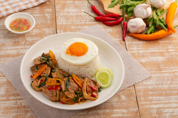 Cooked Rice and Stir Fried sliced duck breast with Thai Basil in white plate.topped fried egg,Thai food.