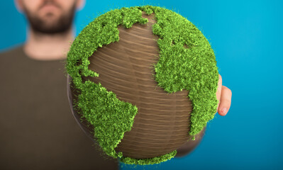 Image of a man holding a wooden globe covered in lush green grass, symbolizing environmental...