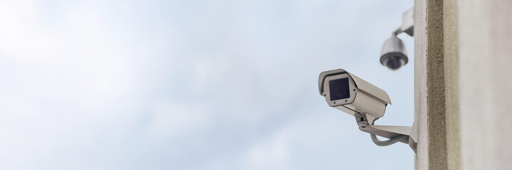 Long banner, Close-up of a security camera on a multi-story building.