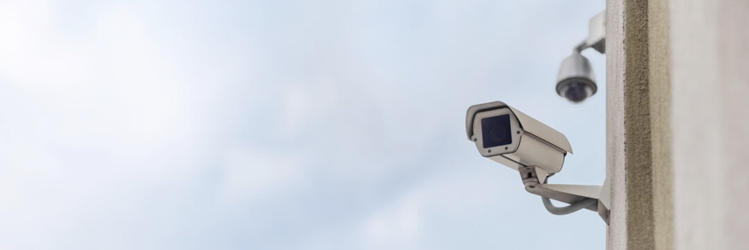 Long banner, Close-up of a security camera on a multi-story building.