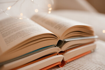 Stack of open paper books with glowing magic lights close up