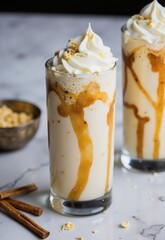 Caramel Cider Floats A creamy, spiced beverage topped with whipped cream and drizzled caramel sauce, served in tall glasses on a marble table