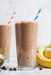 Enjoy a refreshing chocolate milkshake with banana and peanut butter, served in a tall glass with a colorful straw