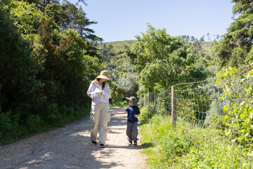 Fototapeta premium Mother and son enjoying a walk in nature on a sunny summer day