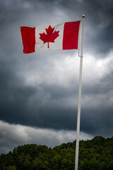 Canada flag flying against dark and moody sky