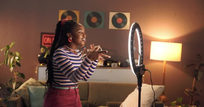 Live streaming, ring light and talk with black woman in home for influencer, promotion or smile. Social media content creator and recording with person and phone for vlog broadcast or follower advice