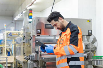 Factory worker inspecting package on conveyor belt