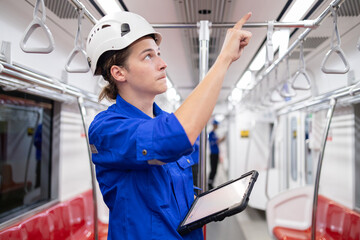 Portrait of young engineer of electric locomotive holding tablet in train