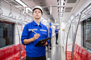 Portrait of young engineer of electric locomotive holding tablet in train