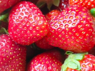 Partial view of a wicker basket filled with fresh red strawberries, placed on a clean white...
