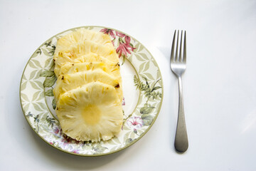 Pineapple on a plate on a white background