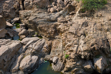 Natural rock formations and water pools in a dry landscape