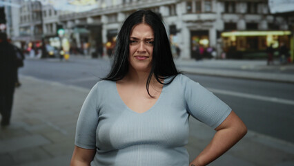 Woman in a city street looking frustrated with hands on head, expressing emotion in an urban environment, showing stress and concern on an outdoor bustling day.