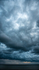 Dramatic overcast sky with dark storm clouds gathering above the calm ocean waters